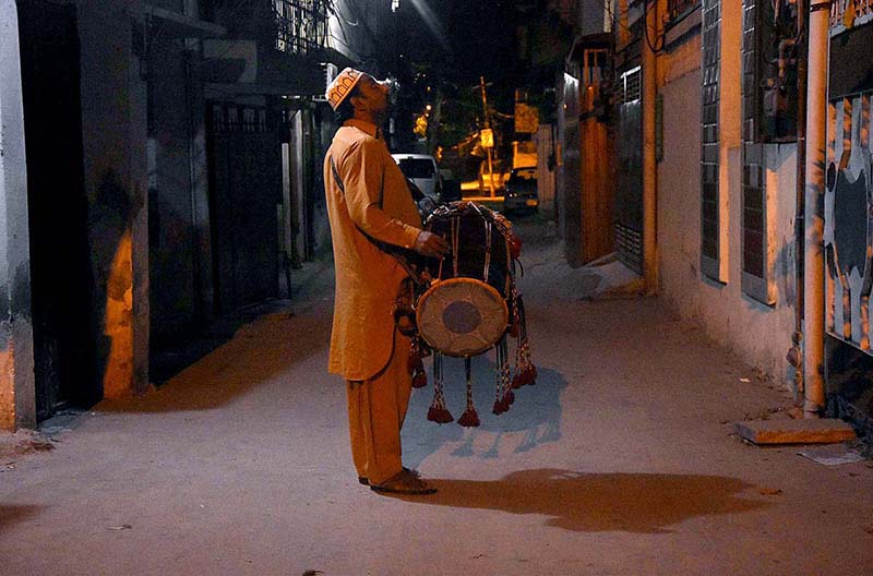 A drum beater walks around the residential area, beating his drum to wake up the people for sehri during holy fasting month of Ramzan-ul-Mubarik