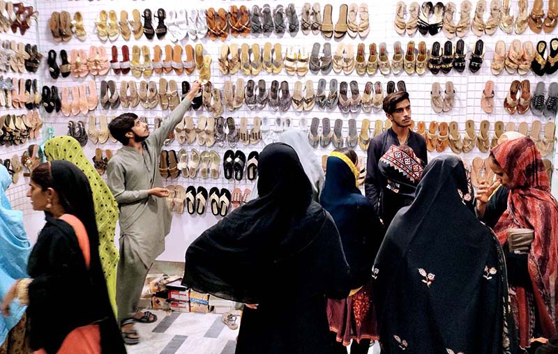 Women selecting and purchasing shoes at Resham Gali in connection with upcoming Eid-ul-Fitr preparation