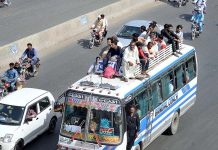 People traveling on rooftop of passenger bus to reach their hometown to celebrate Eidul Fitr with their loved ones