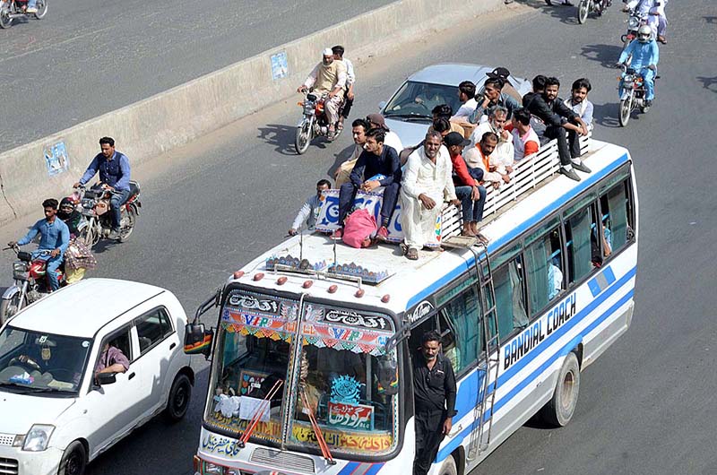 People traveling on rooftop of passenger bus to reach their hometown to celebrate Eidul Fitr with their loved ones