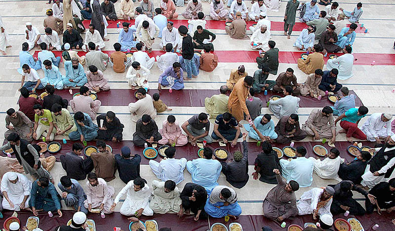 A large number of people are sitting and waiting to break their fast during the Holy Month of Ramadan at Jamia Muhammadi Masjid near Sheikh Zayed Chowk