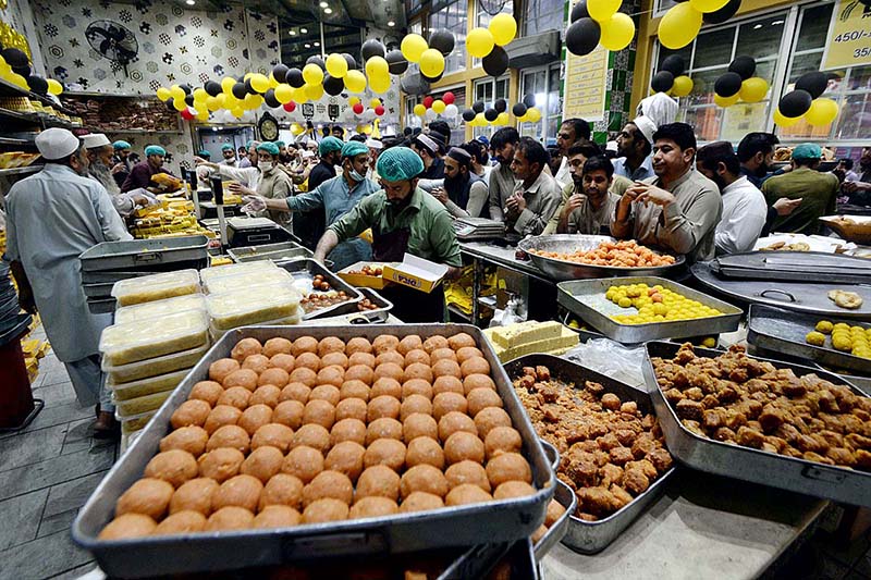 People busy in purchasing sweets at a shop in preparation for the upcoming Eid-ul-Fitr celebrations