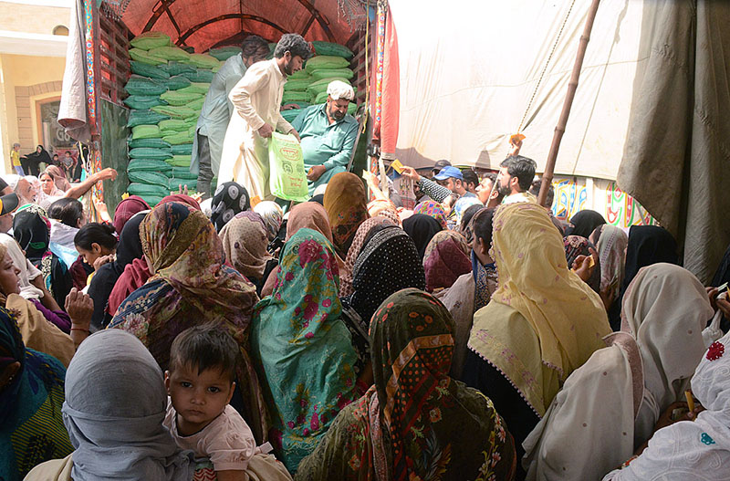 Women are receiving free bags of flour from a distribution center organized by the Federal Government