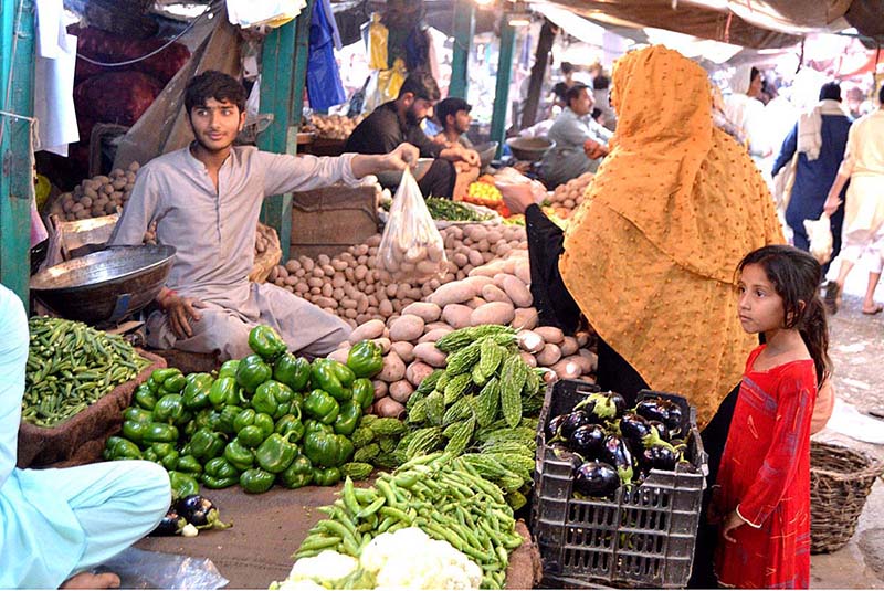 A woman is shopping vegetables at Ramadan Bazaar