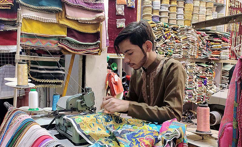 A worker embroidering on the ladies wear at his workplace in connection with upcoming Eid-ul-Fitar