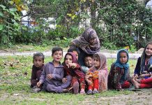 A group of gypsy children siting at a roadside greenbelt in Federal Capital