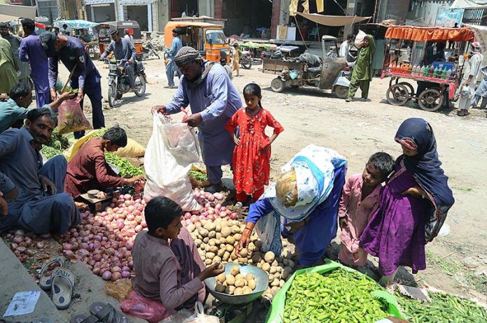 People purchasing vegetables from roadside vendors at vegetable market