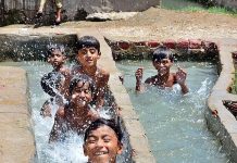 Children enjoying in the watercourse to get some relief from hot weather