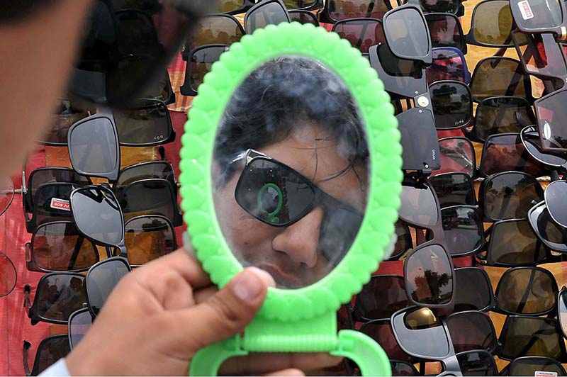A person selecting sunglasses from roadside vendor in Federal Capital