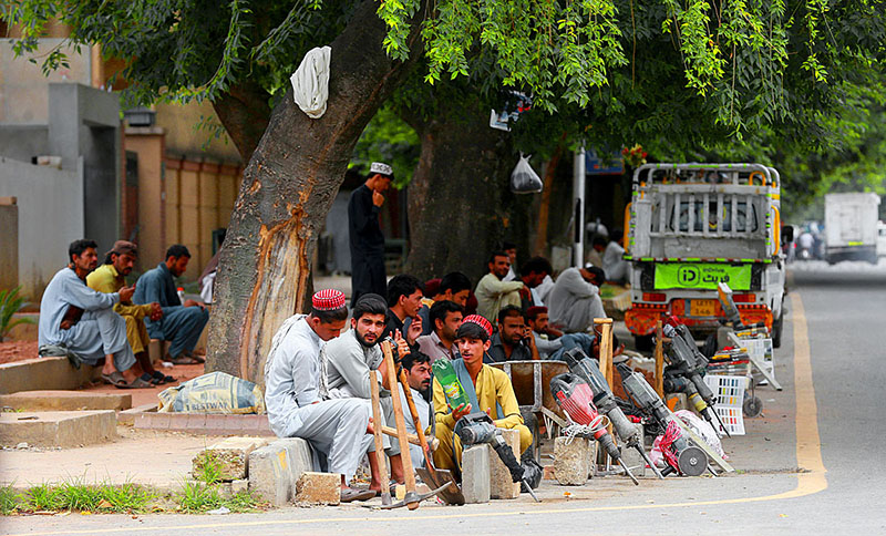 Labourers sitting on the roadside waiting for clients to be hired for daily wage at Jinnah Super Market