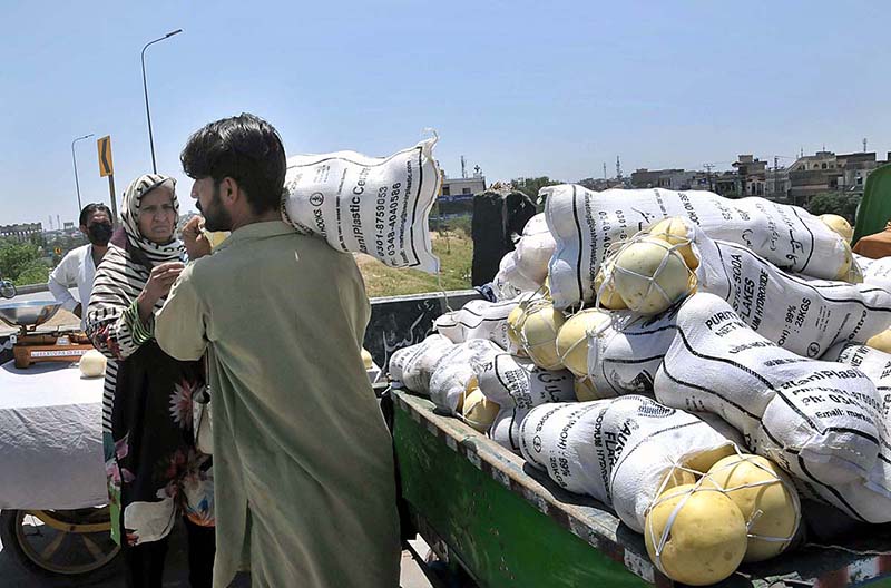 A woman purchasing melon from vendor at Khanapul