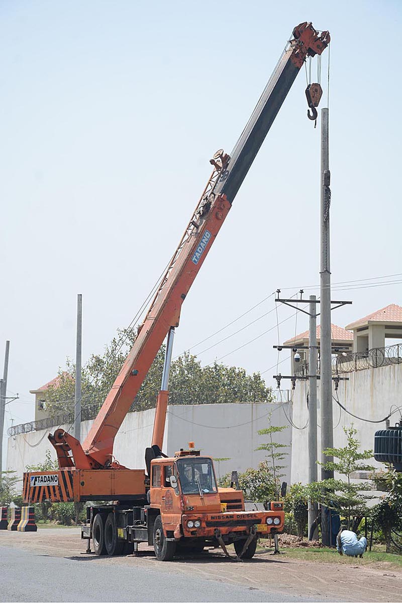 FESCO employees are installing new electricity poles with the help of a crane