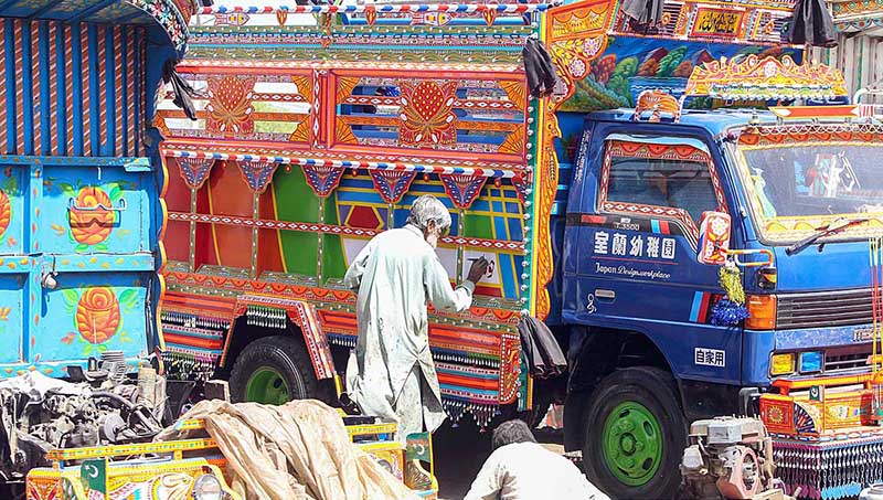 An artisan painting a delivery truck at Pirwahdi