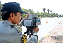 Traffic Police officials checking the speed of vehicle with speed gun at Jinnah Avenue