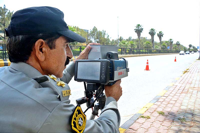 Traffic Police officials checking the speed of vehicle with speed gun at Jinnah Avenue