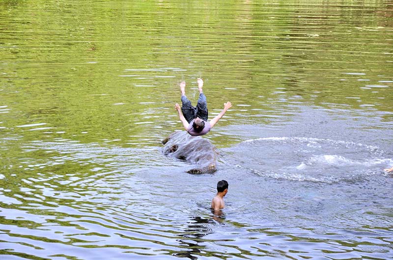 Youngsters swimming in Korang Nullah to get relief from hot weather