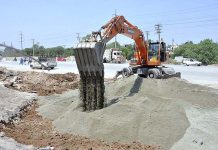 Labourers busy in construction work of IJP Road during development work in Federal Capital