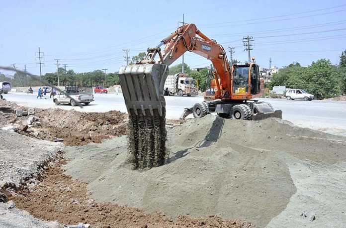 Labourers busy in construction work of IJP Road during development work in Federal Capital