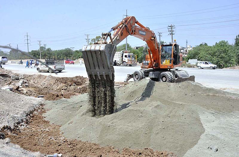 Labourers busy in construction work of IJP Road during development work in Federal Capital