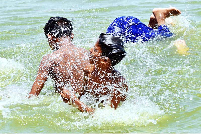 Children enjoying bath in water pond to get relief from hot weather in city