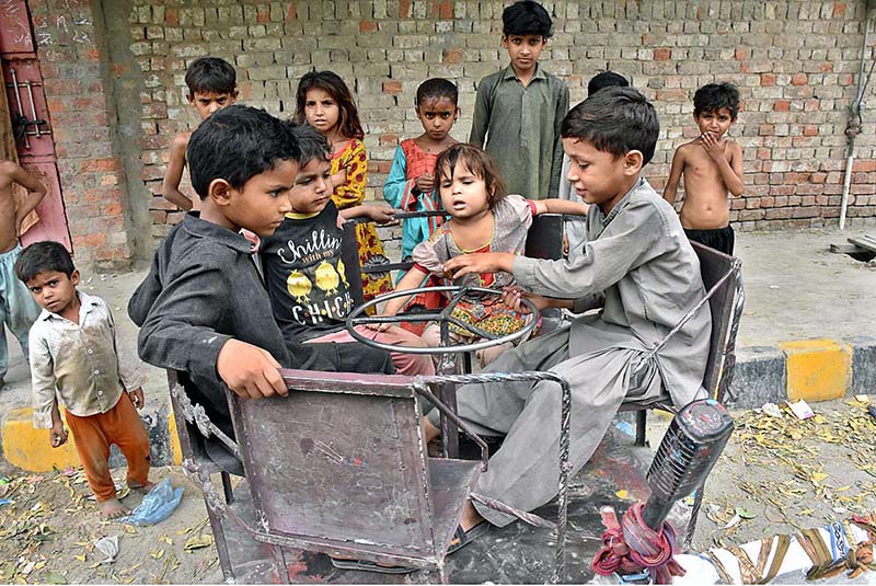 Children enjoying a swing at marry-go-round outside their houses at Rice Canal Road