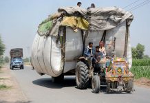 An over loaded tractor trolley on the way at busy Naranwala Road creating hurdles in the smooth flow of traffic and needs the attention of concerned authorities