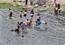 Youngsters jumping and bathing in water channel of Rawal Dam in Federal Capital to get some relief from hot weather in Federal Capital