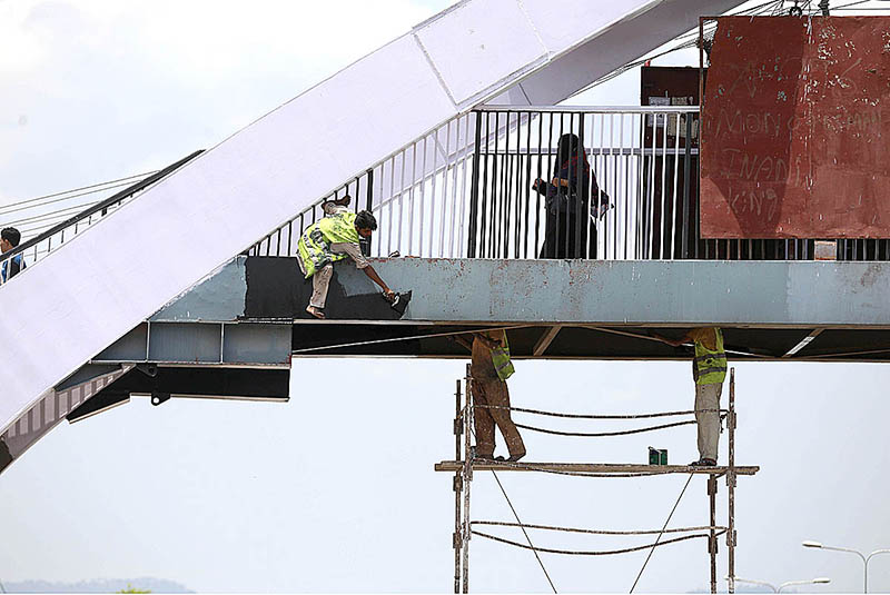 CDA workers painting a pedestrian bridge at Kuri Road