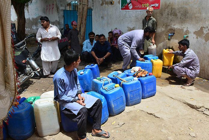 Peoples filling their pots with clean drinking water from tap at Latifabad