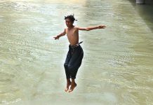 Youngster jumping into the canal to get some relief from hot weather in the city