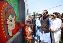 Students painter briefs Assistant commissioner Rao Hashim about his painting during the Wall Chalking Competition in front of Khyber Teaching Hospital organized by District Youth Affairs in collaboration with District Administration