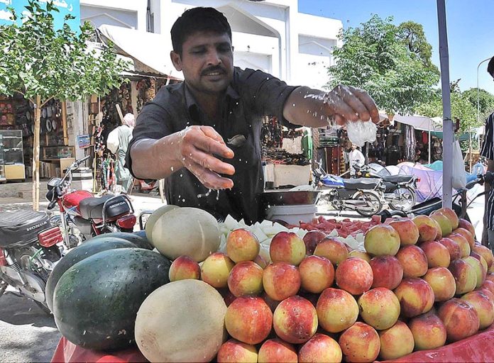 Vendor selling and displaying peach at his roadside setup at Aabpara Market