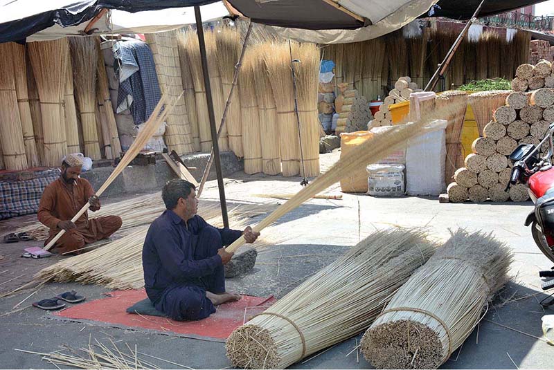Workers busy in making brooms at their workplace