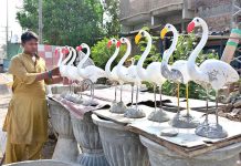 A vendor displaying decorative statue of birds to attract the customers at site area