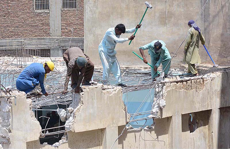 laborers demolish building at Latifabad