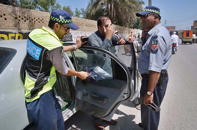 Traffic Warden officials removing tinted glasses from a car during a campaign at Eid Gah road