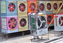A worker busy in preparing a room cooler at his workplace as demand increases in the summer season