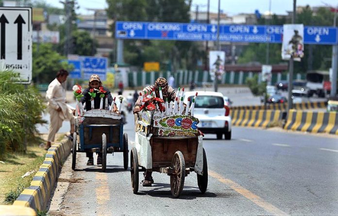Street vendors on the way pushing their carts while looking for customers to sell Qulfi at Airport Road