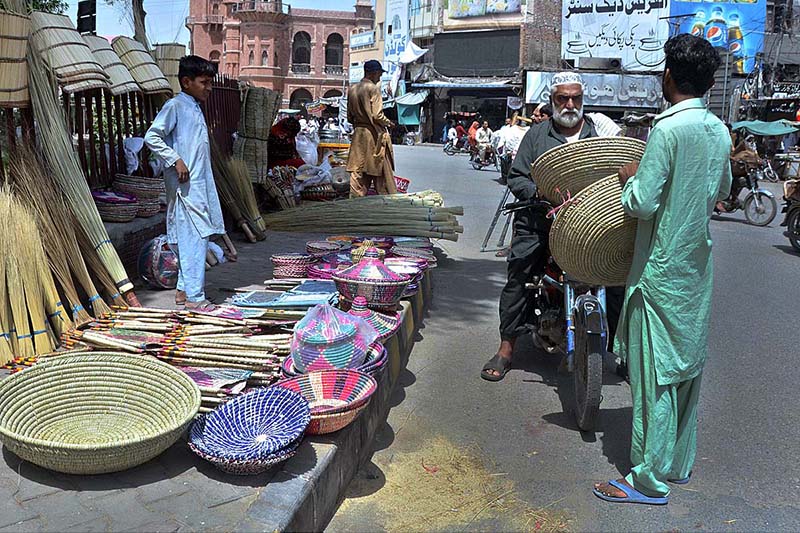 A person purchasing handmade household items from a roadside vendor