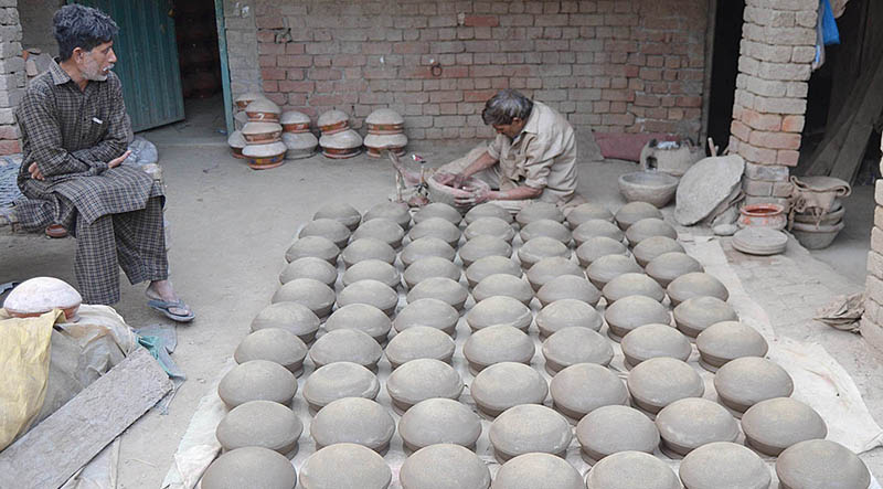 A potter is making traditional clay pots from clay in his workshop at the Kanchi Stop Area