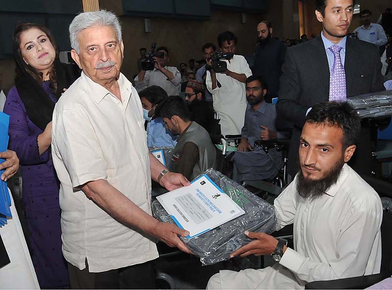 Federal Minister for Education & professional Training Rana Tanveer Hussain distributing wheelchairs to the participants of Prime Ministers Electric wheelchair Scheme for University Students: Distribution Ceremony - Phase 111 organized by Higher Education Commission at HEC