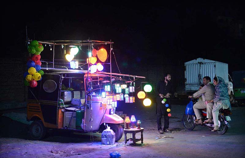 A young man selling fancy lights on his rickshaw