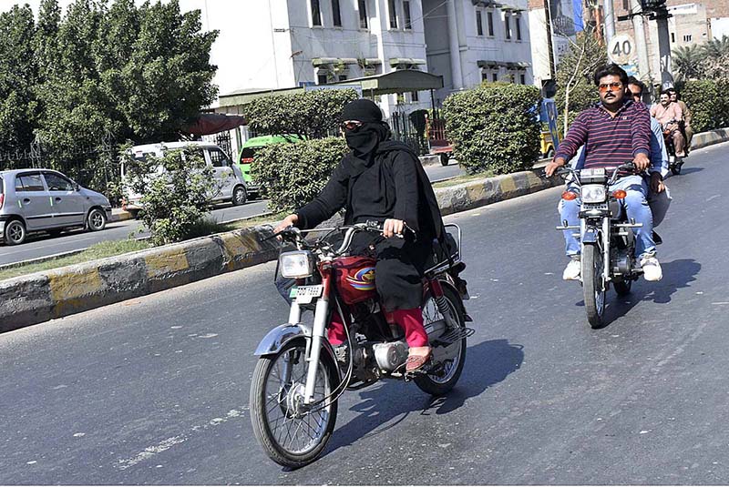 A woman riding a motorcycle near Model Town wearing a Burqa is a reflection of a woman's independence and courage in modern times