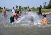 Children enjoying swim in a stream to get some relief from hot weather at Musazai area