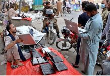 A street vendor displaying used Laptops to attract the customers at his roadside setup in Provincial Capital