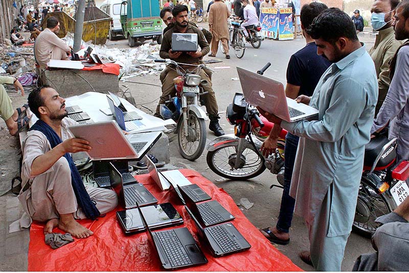 A street vendor displaying used Laptops to attract the customers at his roadside setup in Provincial Capital