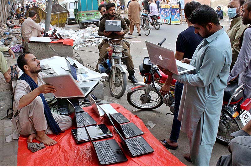 A street vendor displaying used Laptops to attract the customers at his roadside setup in Provincial Capital