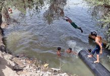 Children enjoying bath in the canal to get some relief from hot weather in the city