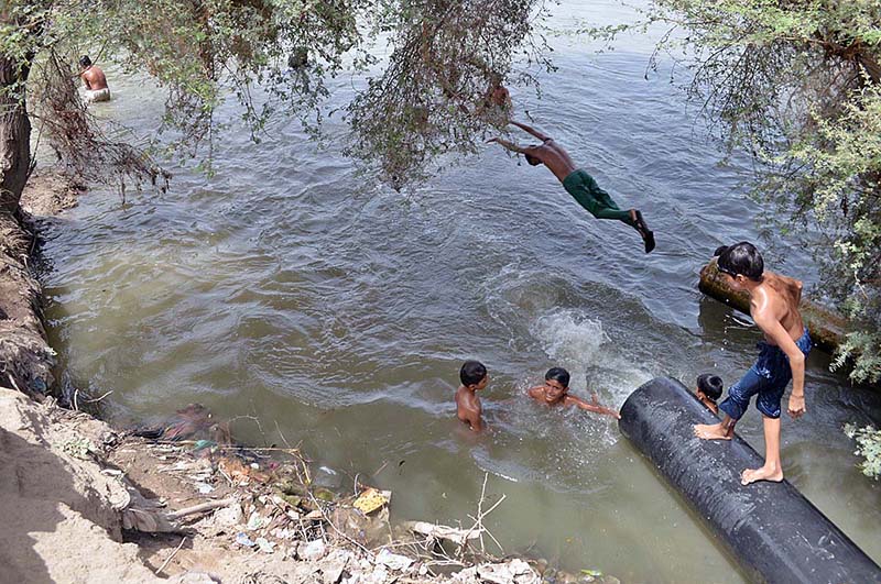 Children enjoying bath in the canal to get some relief from hot weather in the city