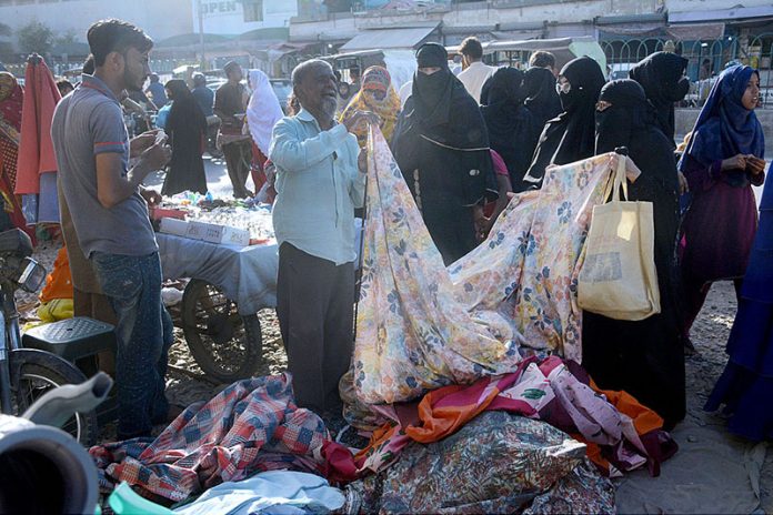 Women selecting clothes at weekly Bazar in Lines Area